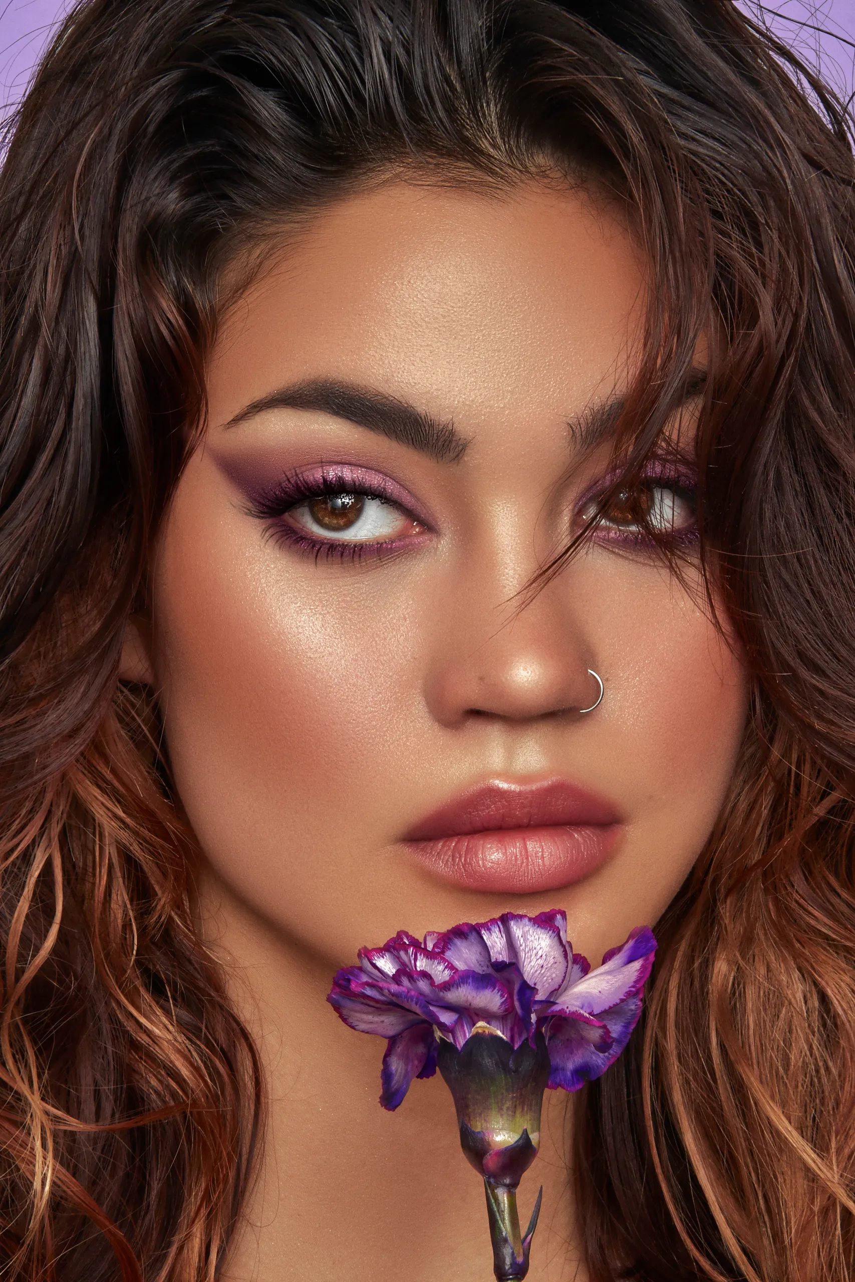 A close up of a woman with a flower in her mouth.