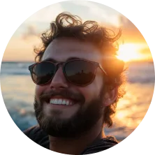 A man with a beard and sunglasses smiling at the camera.